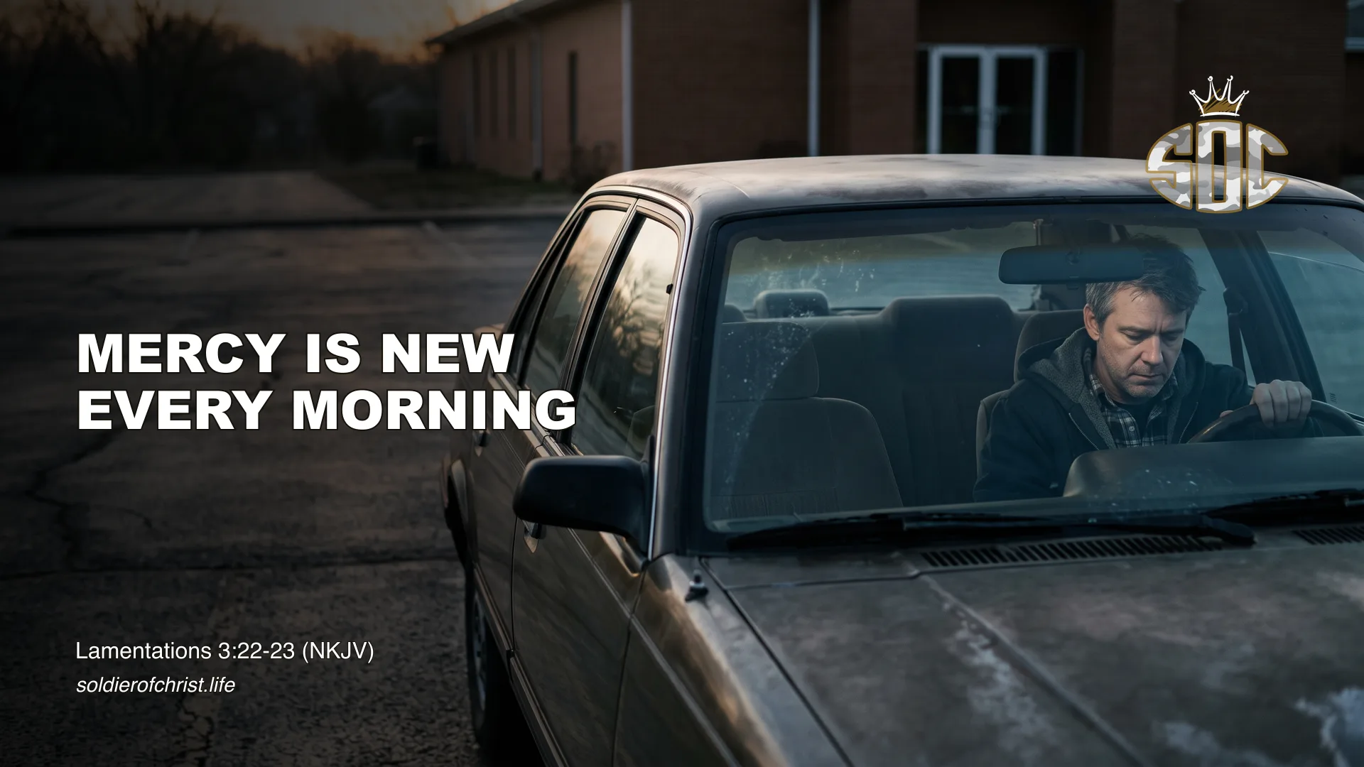 A man sits alone in his car in an empty church parking lot at dawn