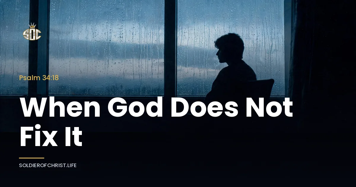 A person sits alone in silhouette by a rain-streaked window at grey dawn